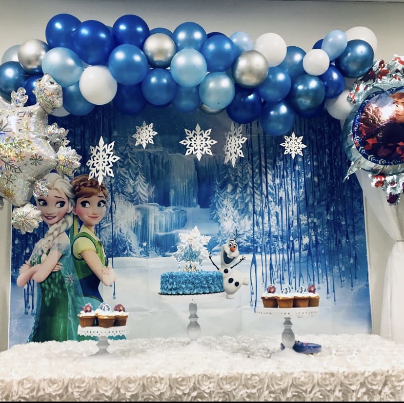 A frozen themed birthday party with balloons and decorations.